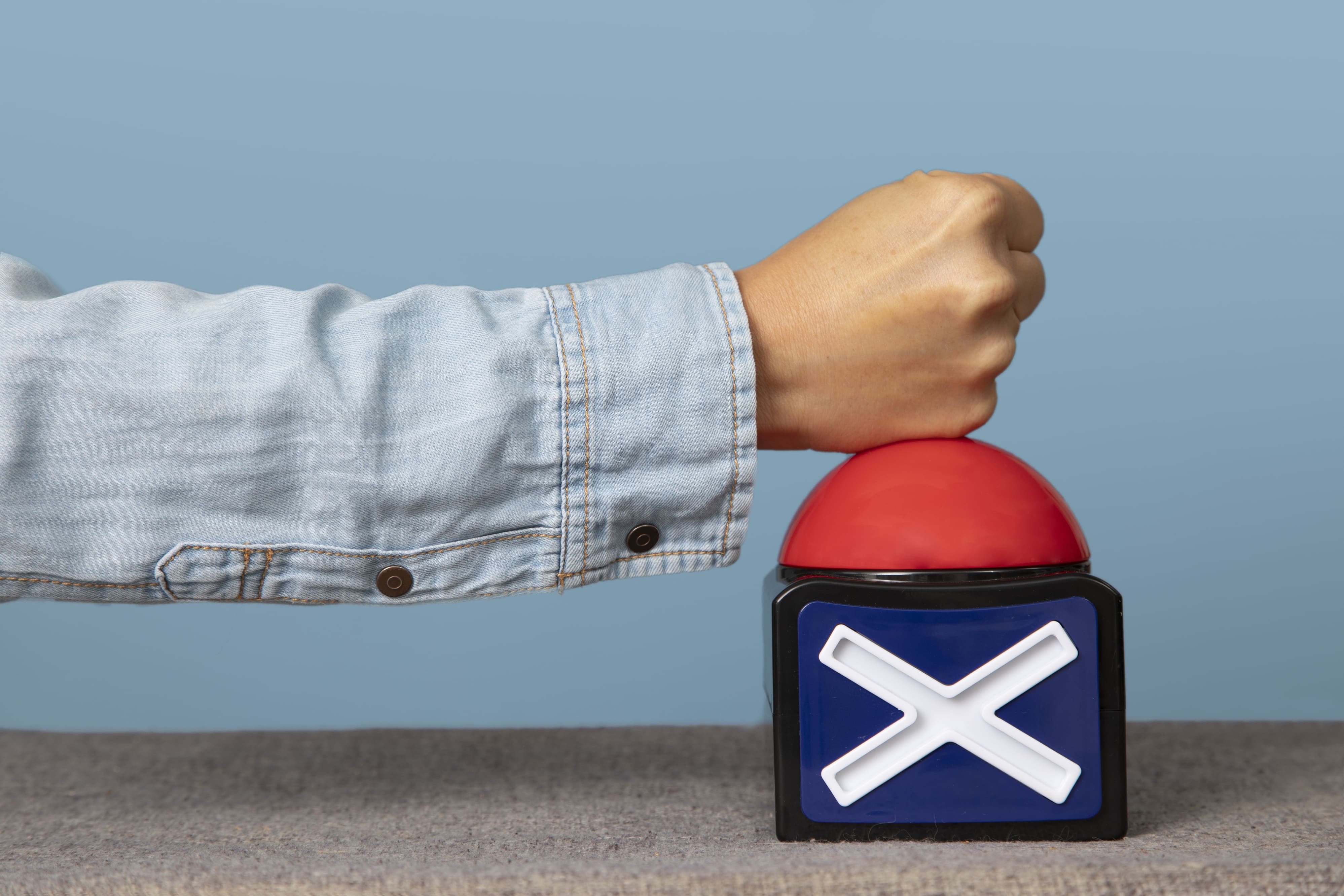 Young adult pressing X buzzer button