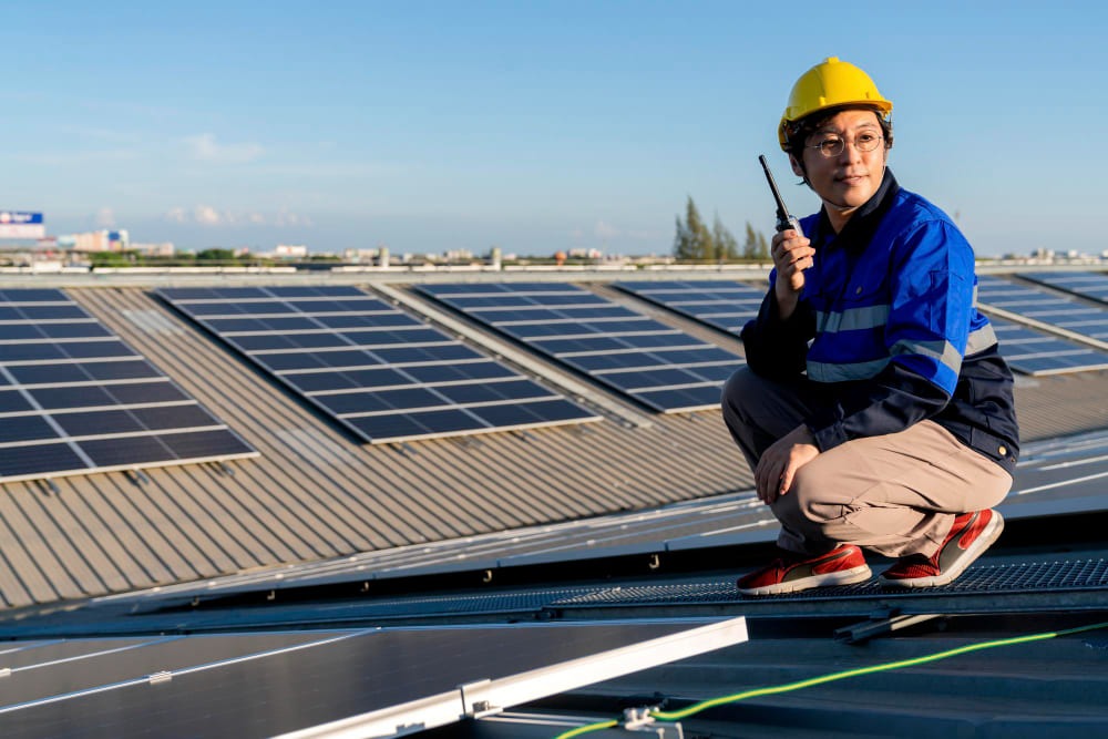 Engineer standing at the rooftop panels
