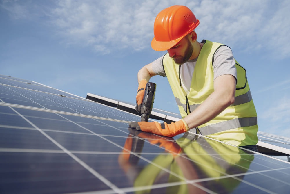 Worker installing solar panel