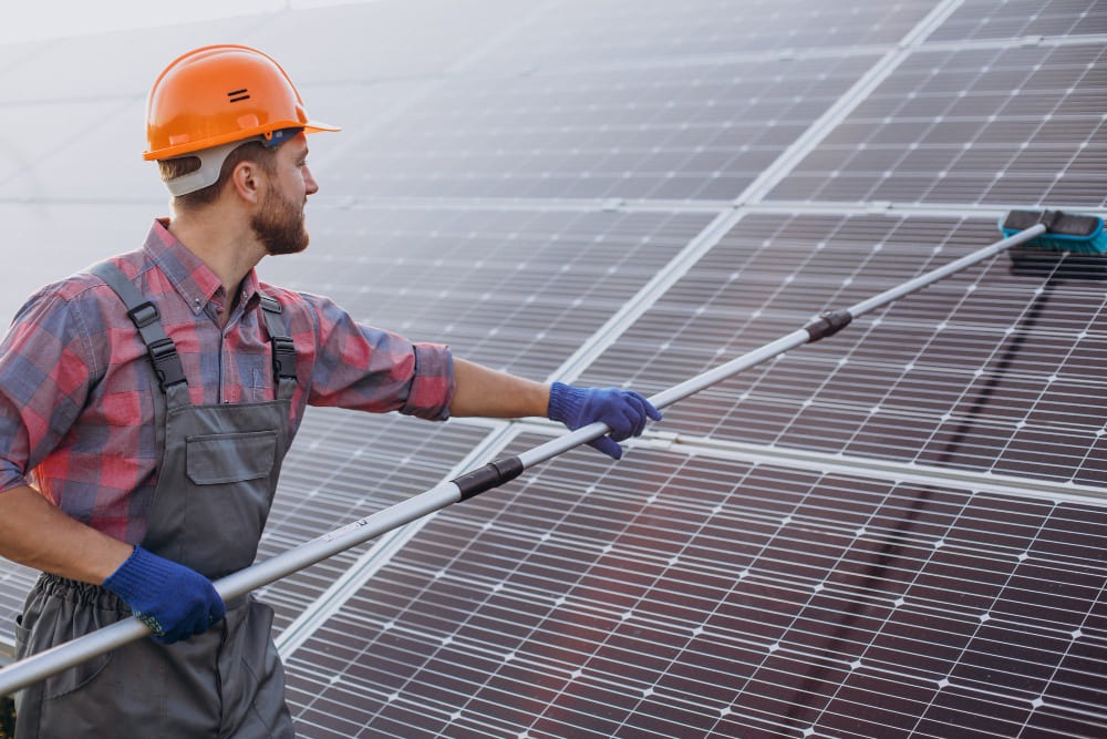 A man brushing solar panel