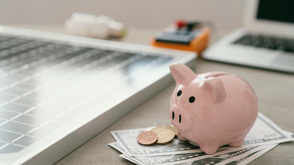 Piggy bank next to a solar panel