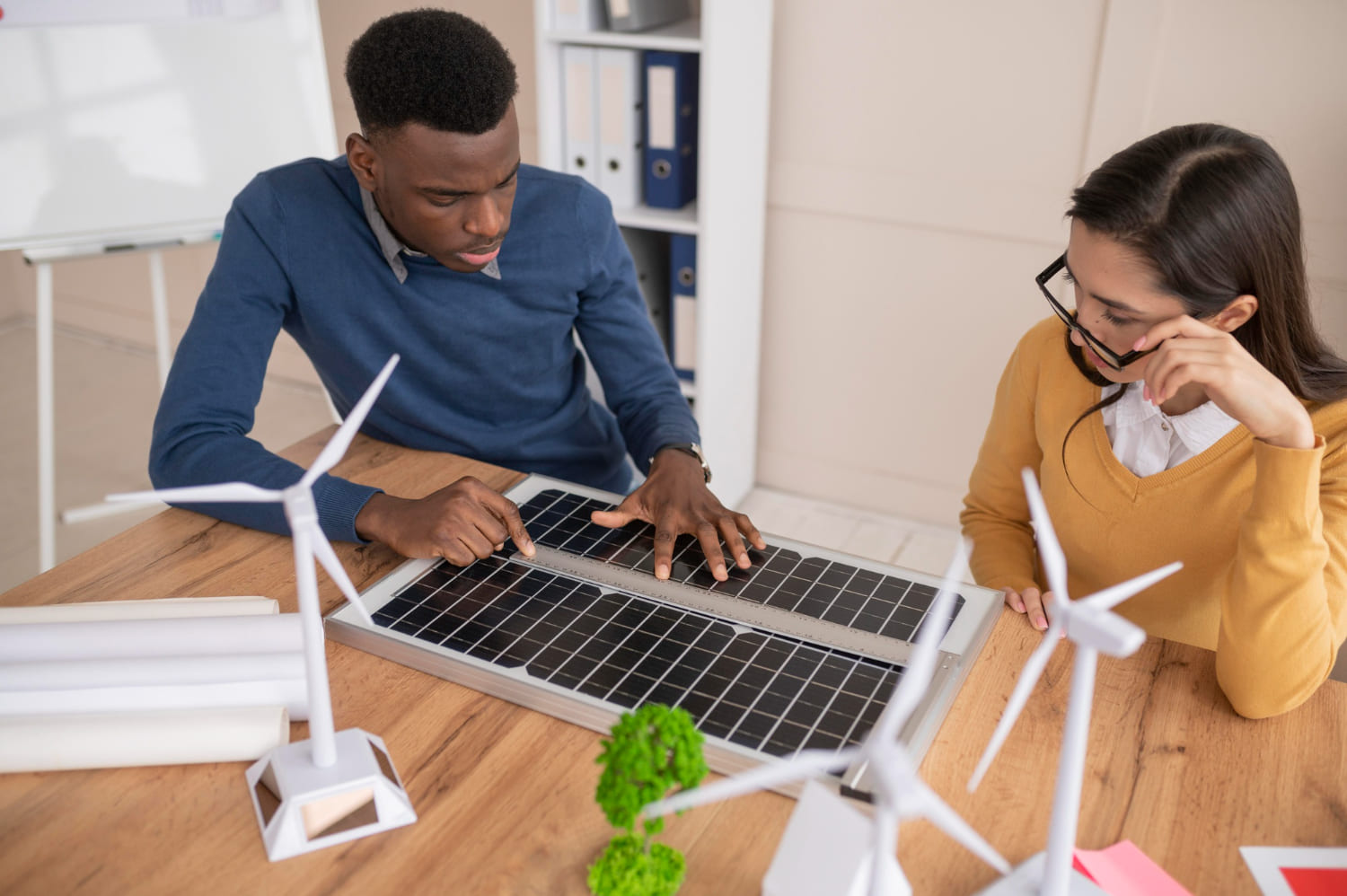 two people checking on a solar panel