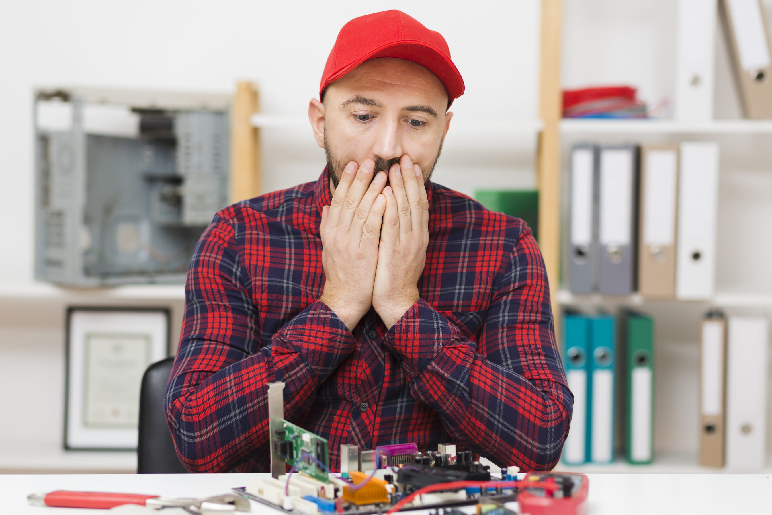 Computer repair technician stressed by motherboard failure.