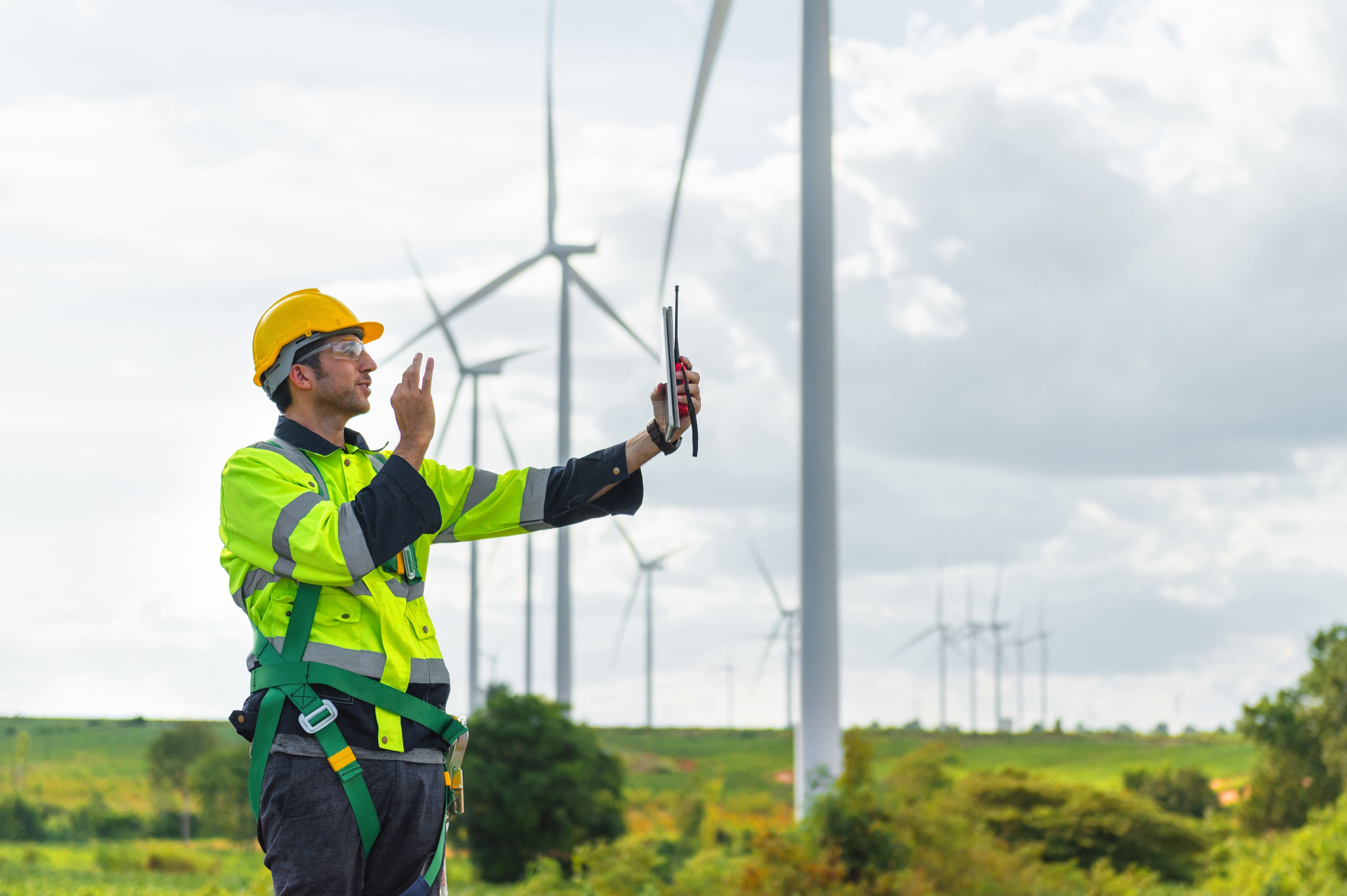 Engineer inspects wind turbines using a tablet device