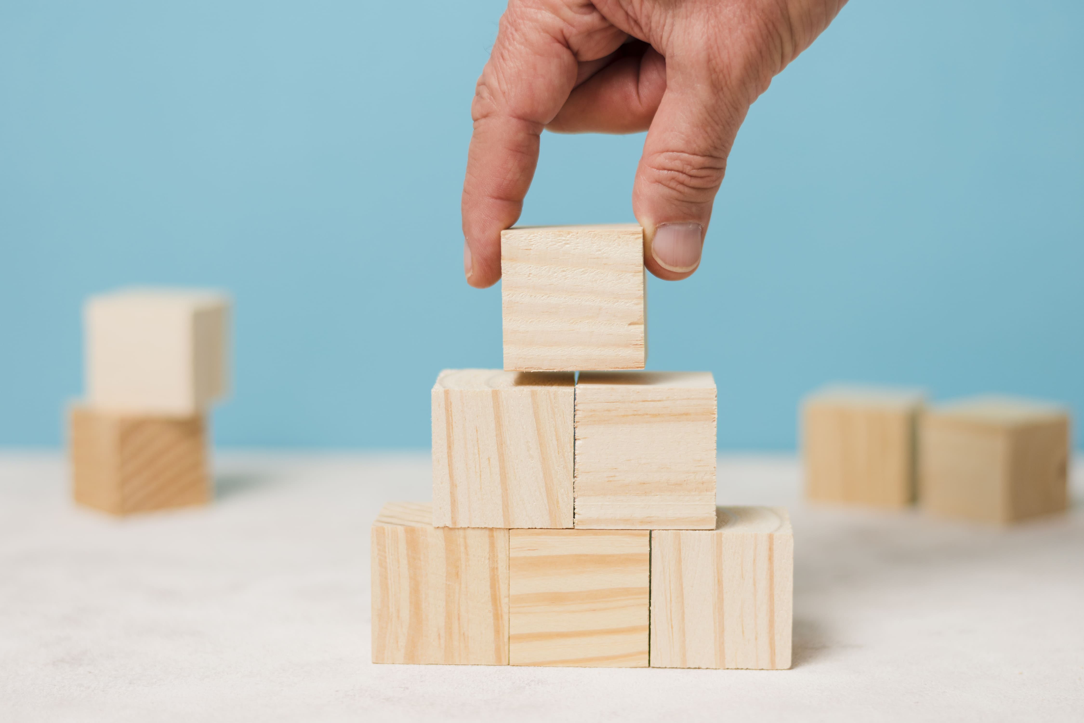 Hand stacking wooden blocks, building a pyramid