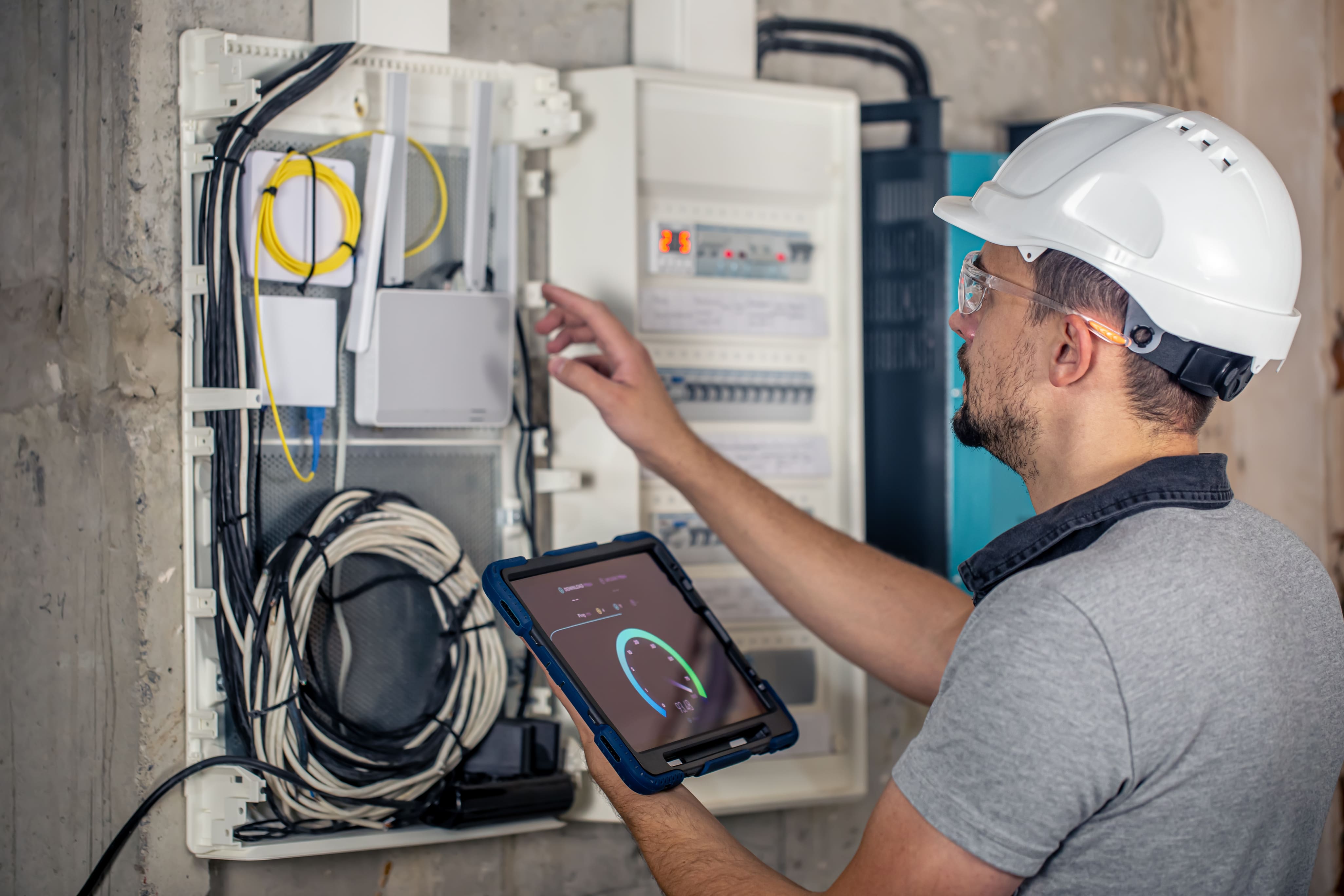 Man an electrical technician working in a switchboard