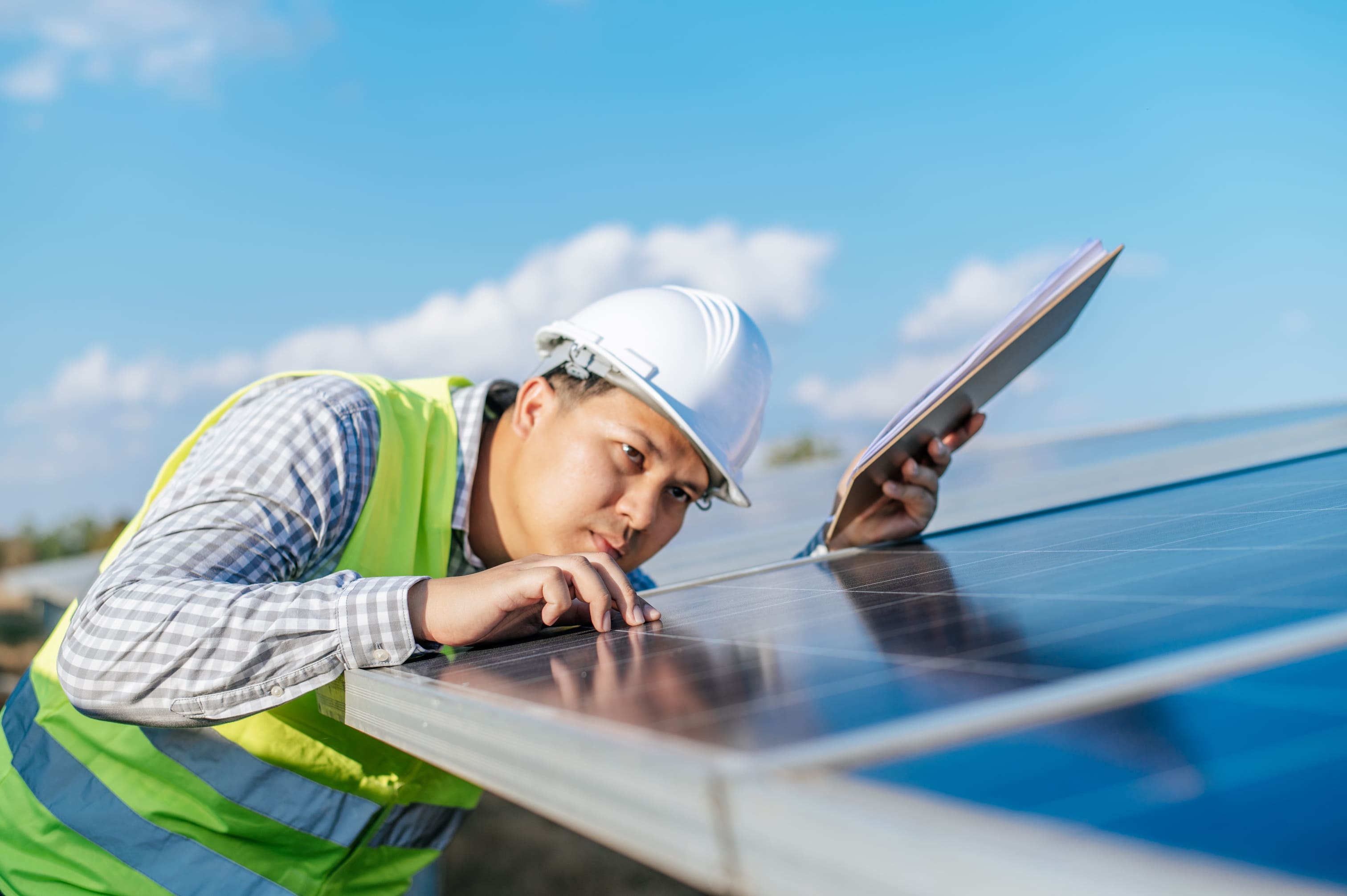 Engineer inspecting a large solar panel up close