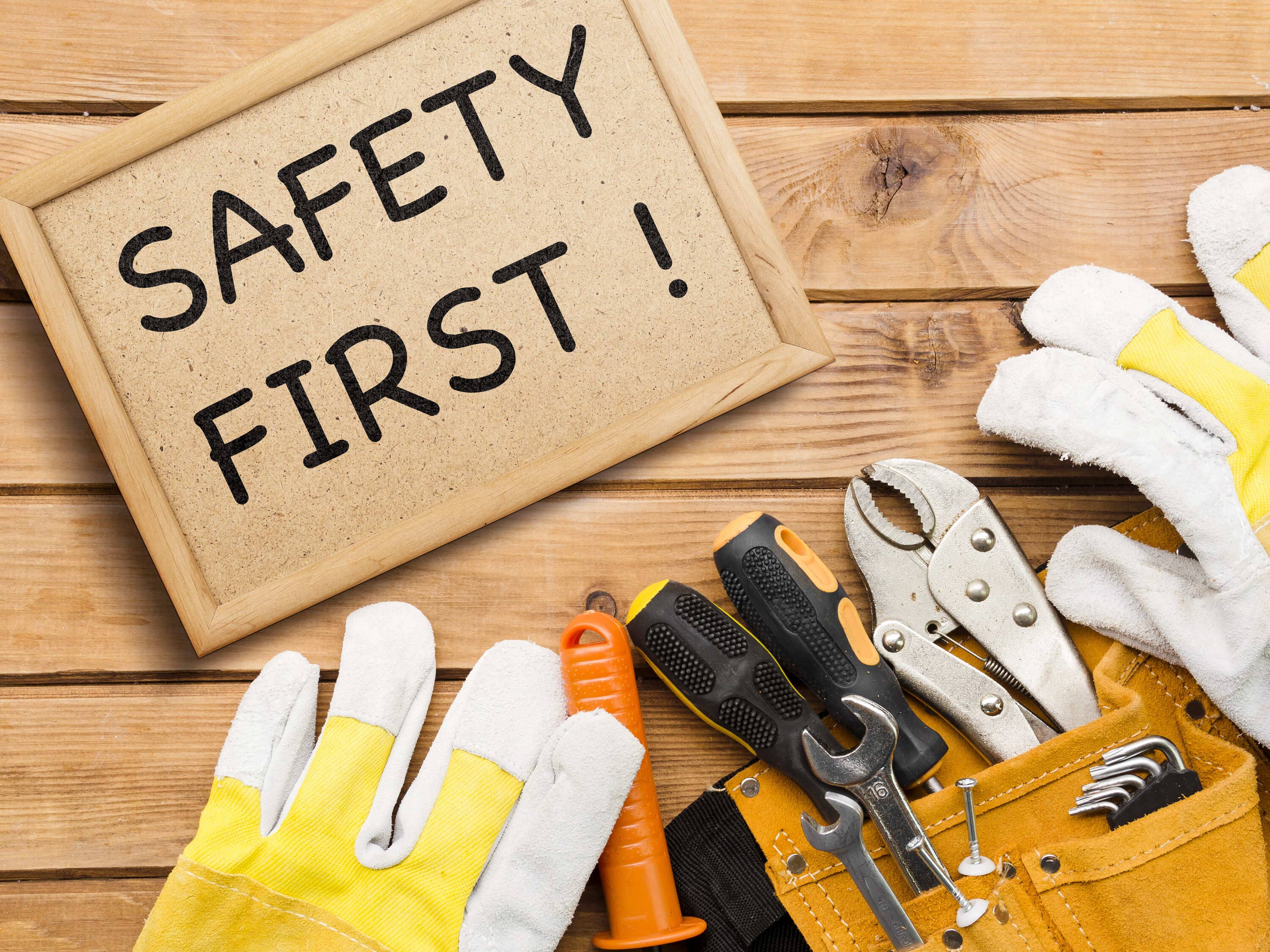 Safety First! sign with protective gloves and tools