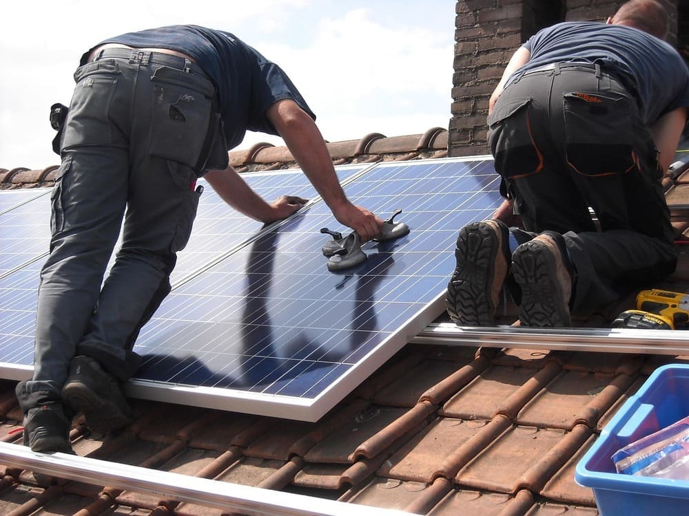 professional cleaning solar panels on residential roof