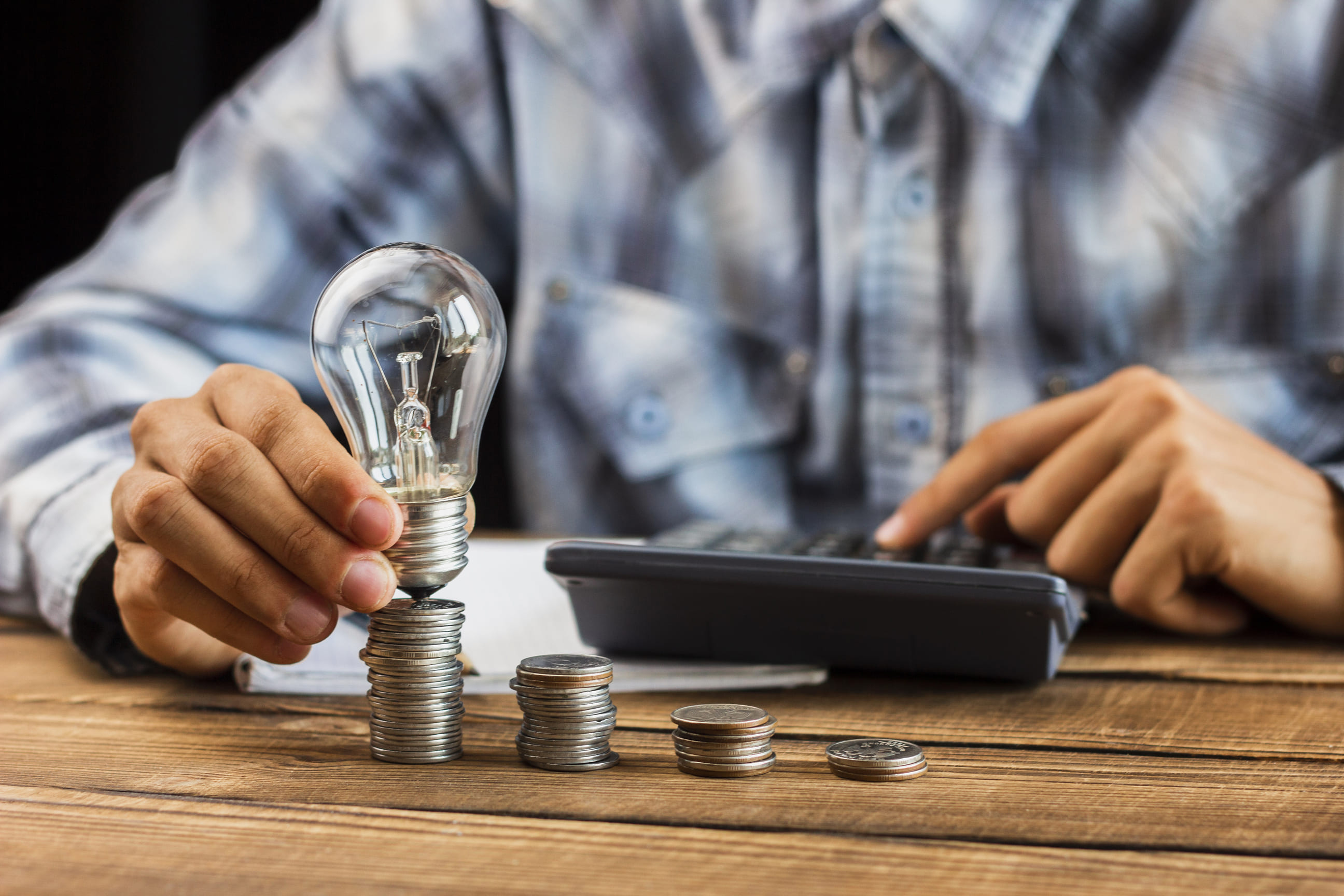 Calculating energy savings with coins and light bulb