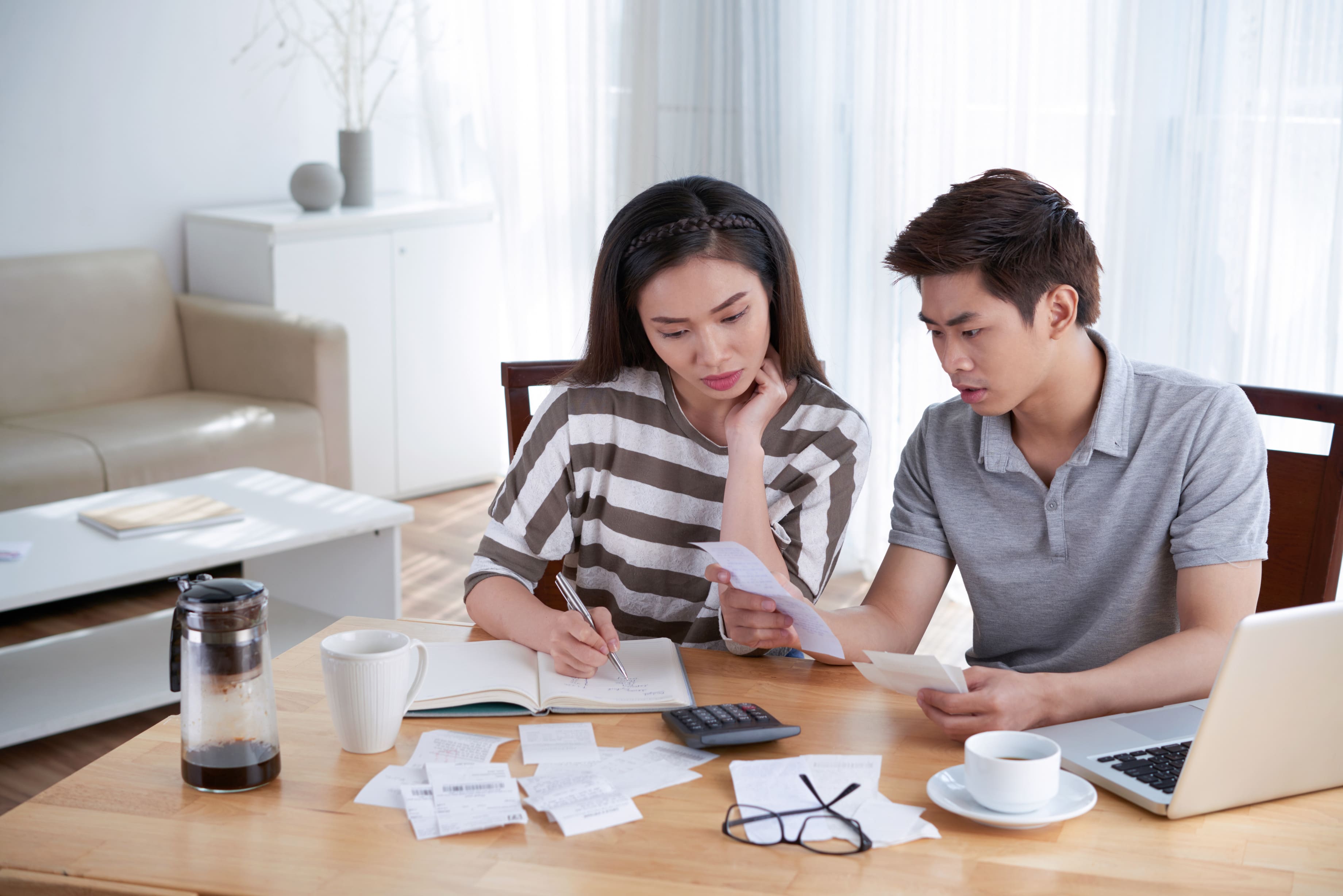 Couple calculates domestic budget, reviewing household expenses