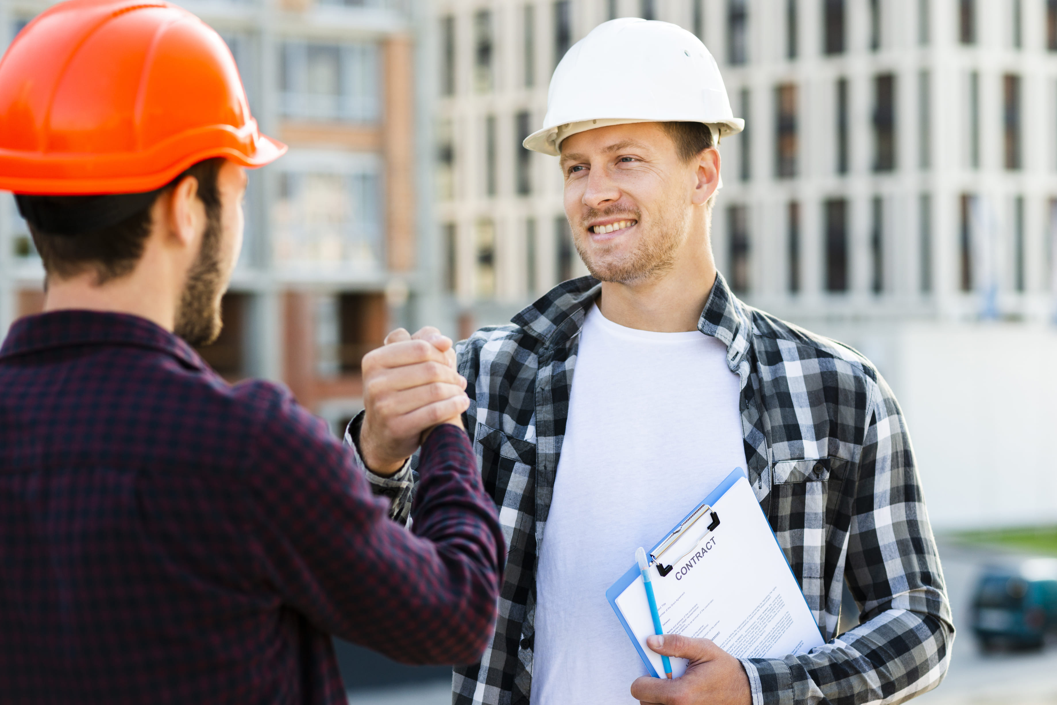 Engineers shake hands after signing contract agreement