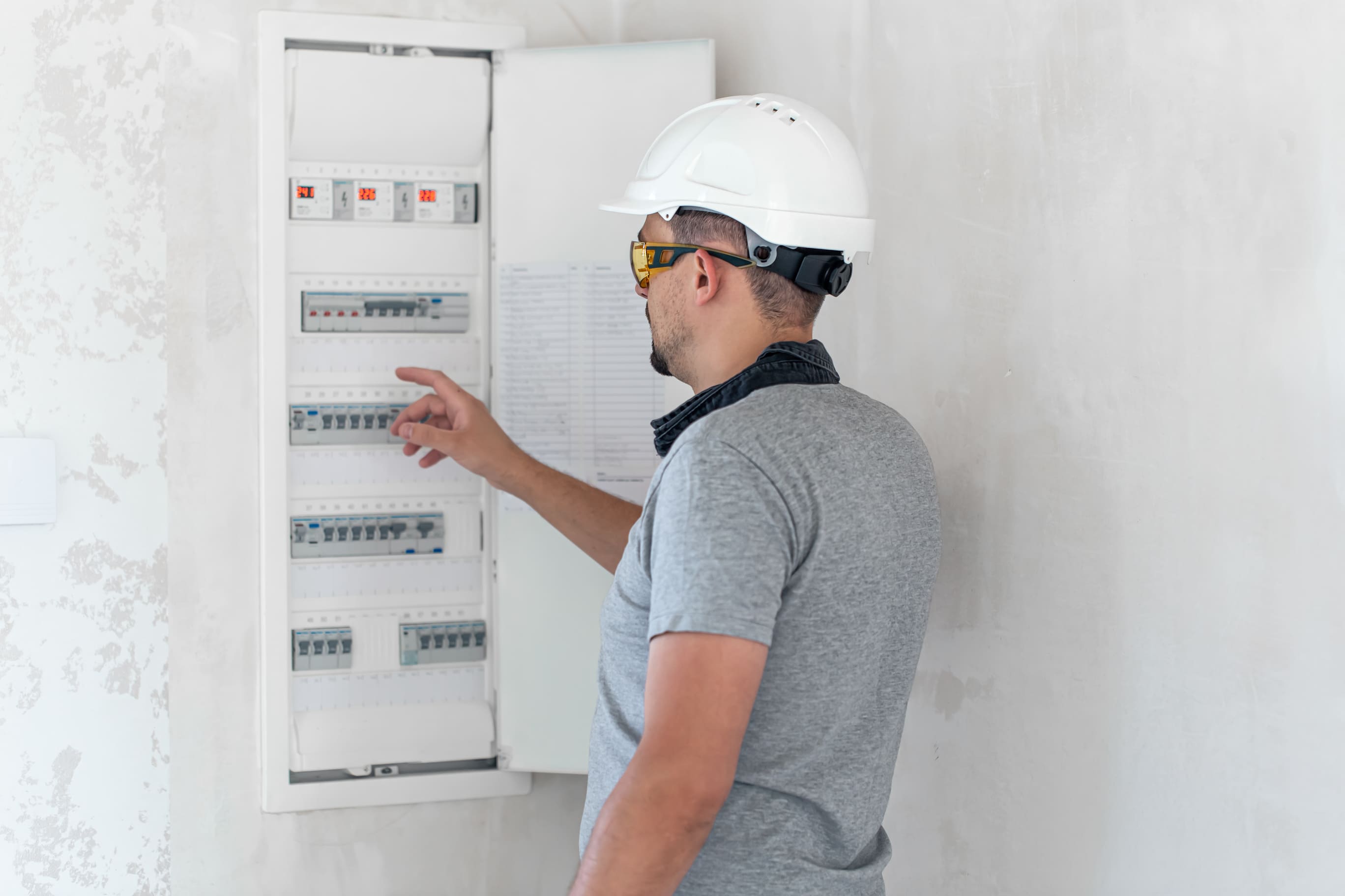 Technician checks fuses in an open electrical panel