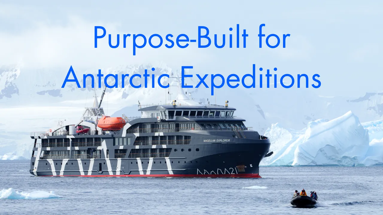 Black and white expedition ship named Magellan Explorer sailing near icebergs in Antarctic waters with a small boat carrying people in orange jackets in the foreground.