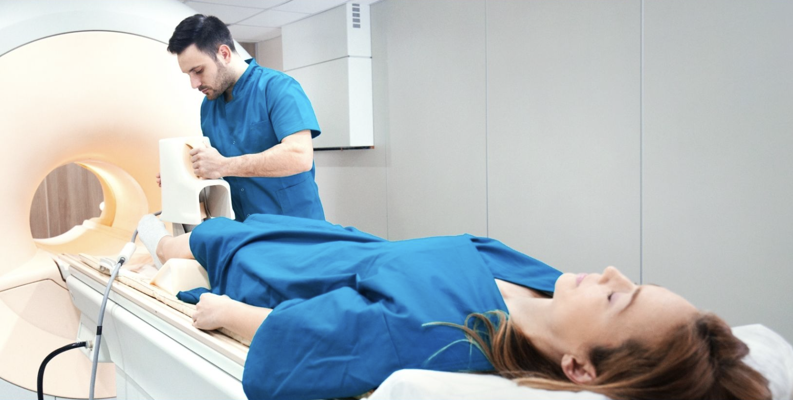 Patient lying supine (on their back) fee-first toward the MRI scanner, with dedicated foot coil array on their right ankle