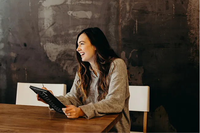 A woman holding a tablet smiling 
