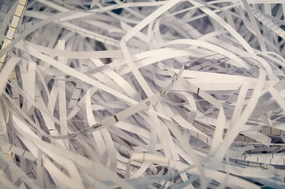 Destruction has a standard: cross-cut shredding for paper, NIST SP 800-88 sanitization for media, and a log that proves both happened.