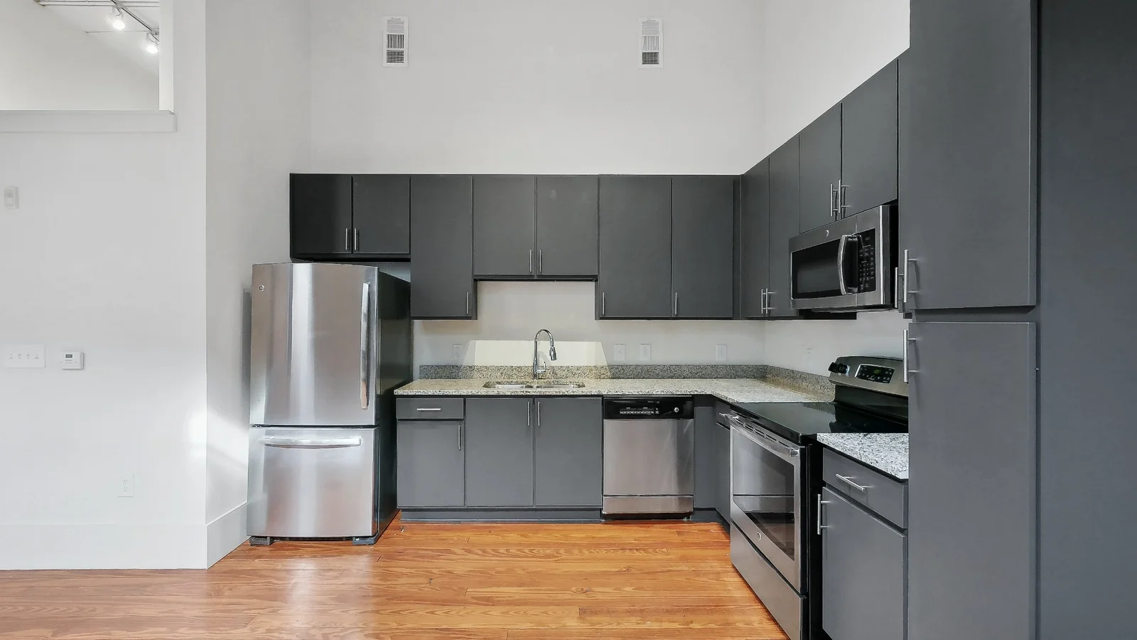 Open concept kitchen with stainless steel appliances and high ceilings at The Lamar Lofts