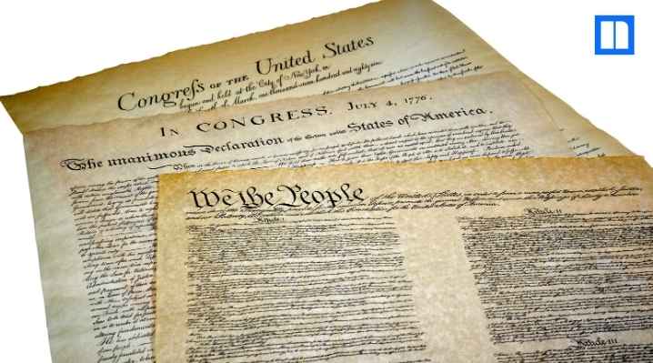 A layered view of historical U.S. documents, including the Declaration of Independence and the Constitution ("We the People").