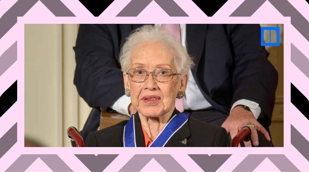 A close-up portrait of NASA mathematician Katherine Johnson wearing glasses and a blue Presidential Medal of Freedom ribbon. She is seated and smiling during an event.