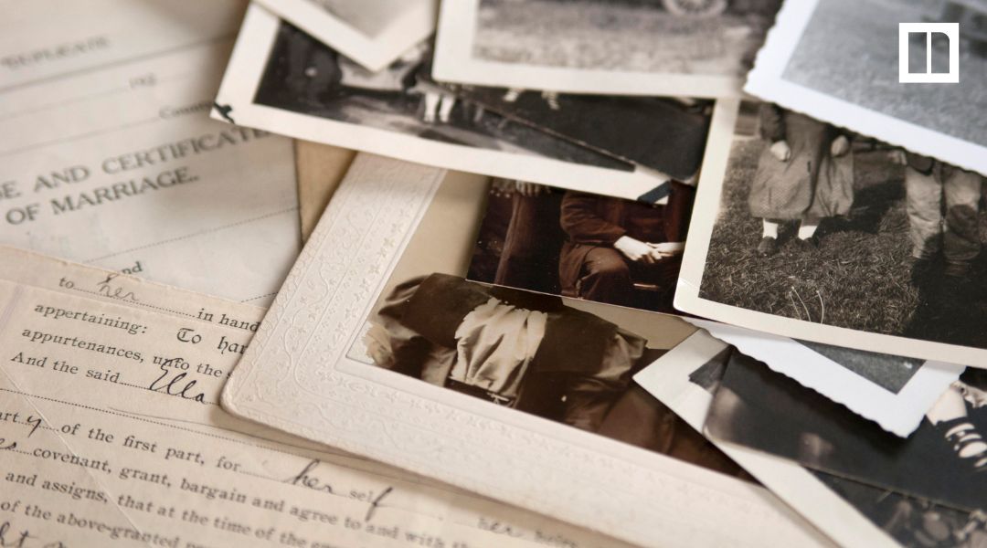 Vintage family photos and historical documents spread across a table.