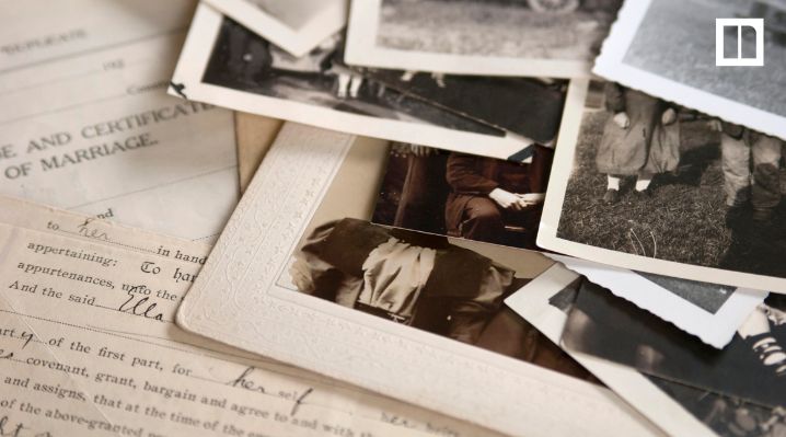Vintage family photos and historical documents spread across a table.