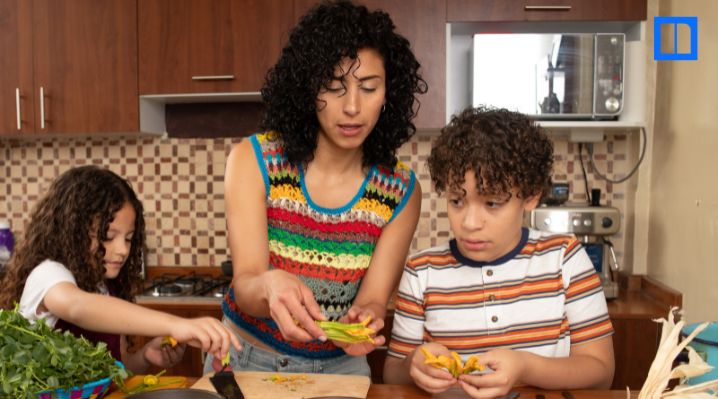 An educator guides two students through hands-on plant observation for Hispanic Heritage Month STEM activities.