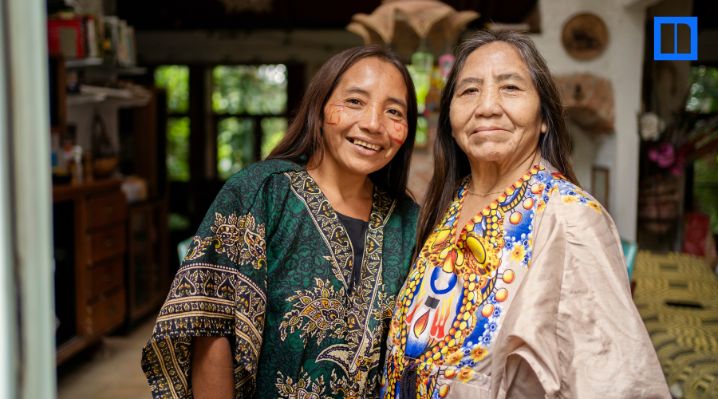 Two women wearing colorful patterned clothing stand together indoors, featured in a Native American Heritage Month STEM education blog.