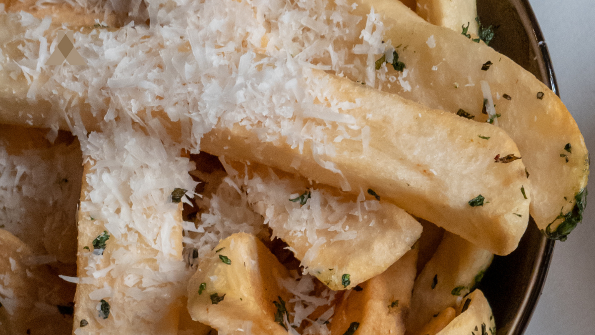 Golden truffle fries topped with grated parmesan — gourmet appetizer featured at Corazón by Baires.