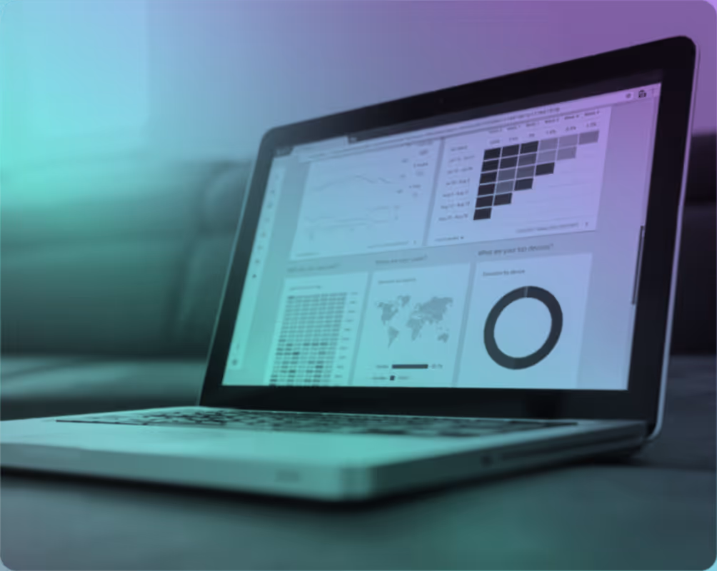 Laptop on a table displaying a dashboard with charts, a world map showing user sessions by country, and a donut chart depicting top device sessions.