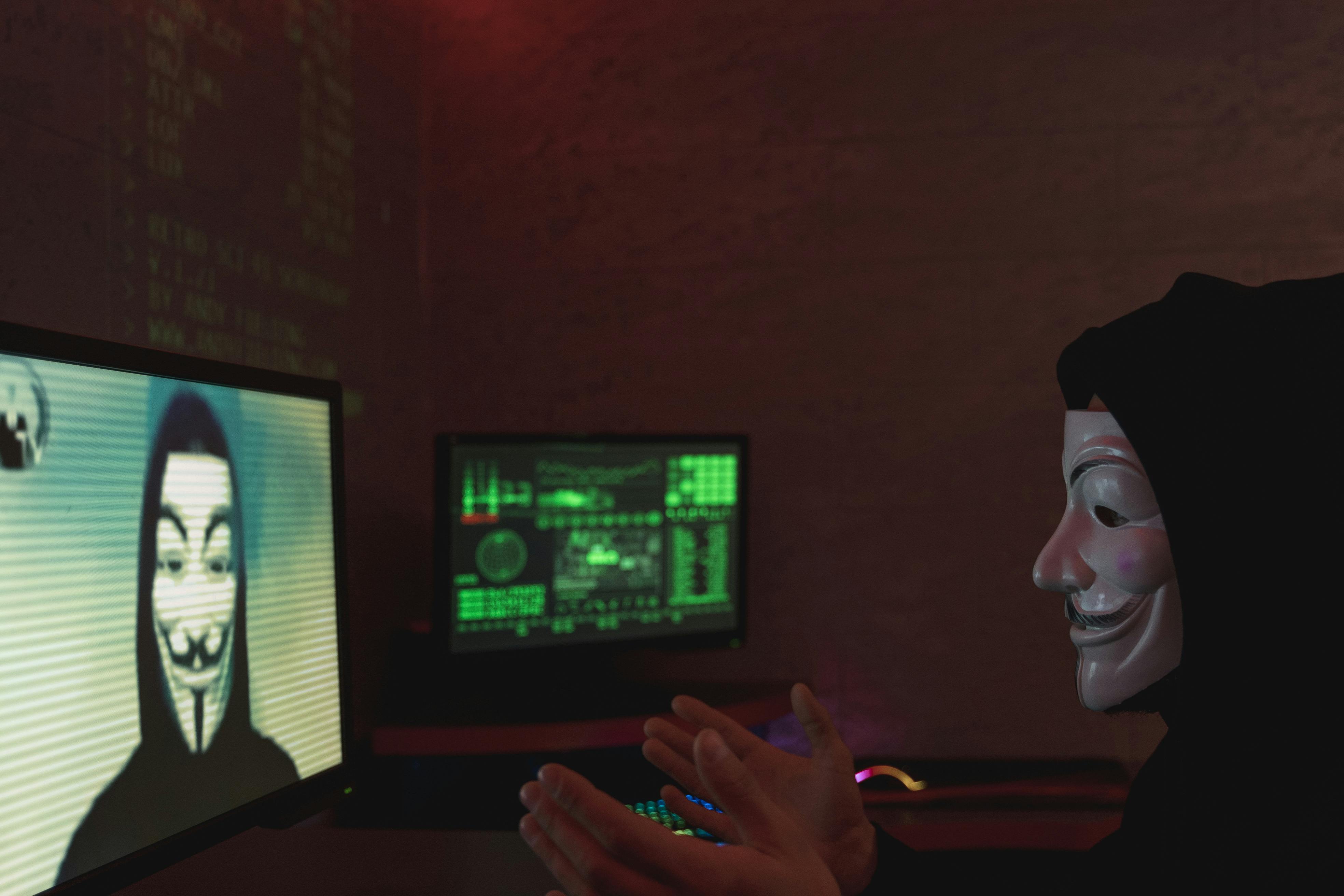 Hacker mit Maske der in IT System eindringt 