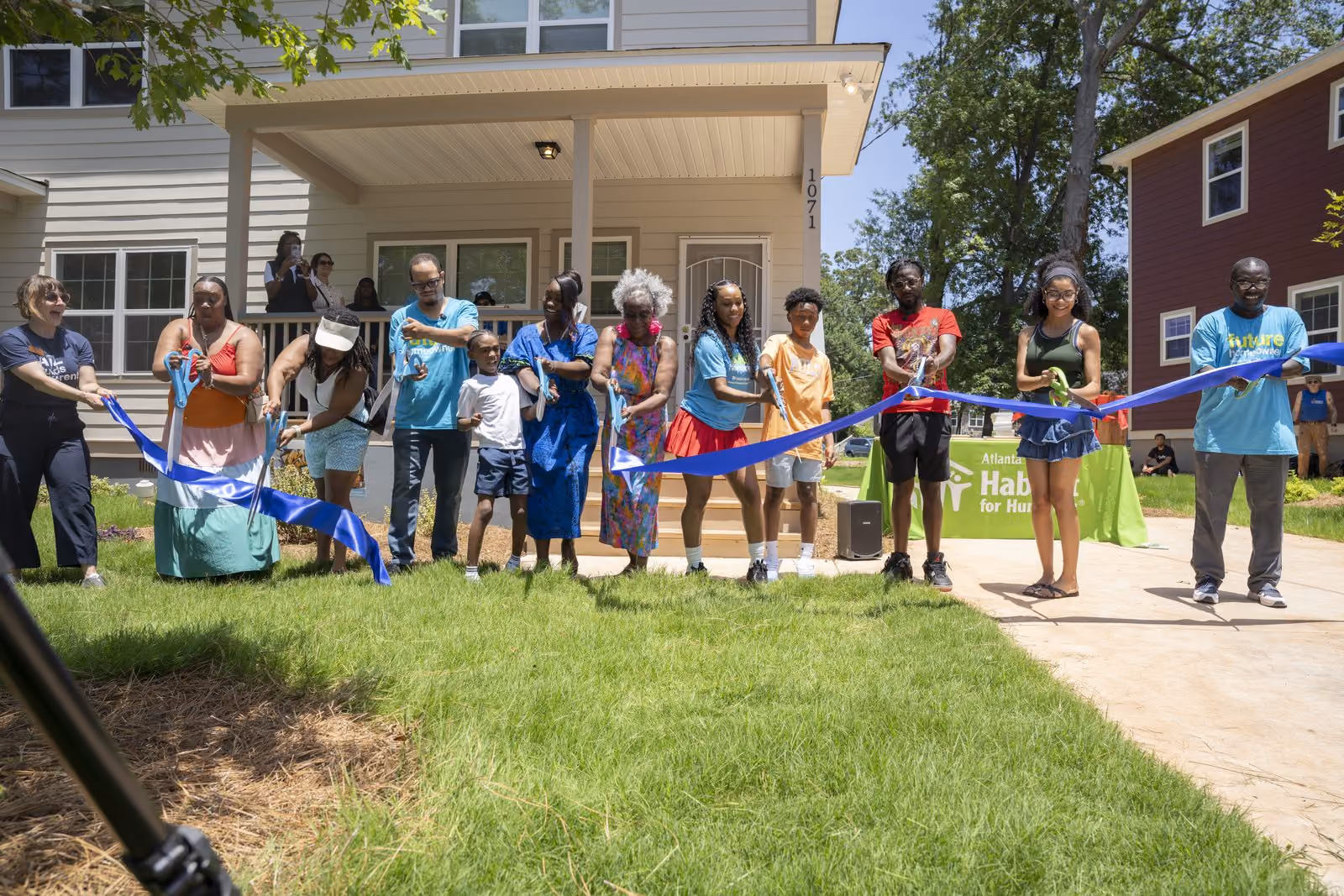 Homeowners and their families cut the ribbon at a Langston Park home dedication