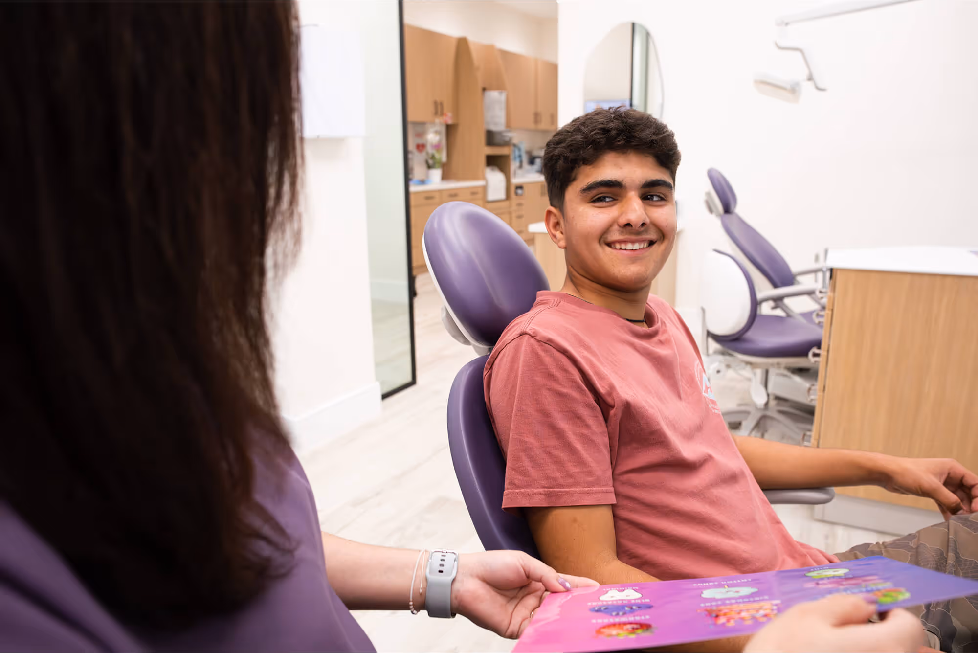 A young man sitting in a dental chair.