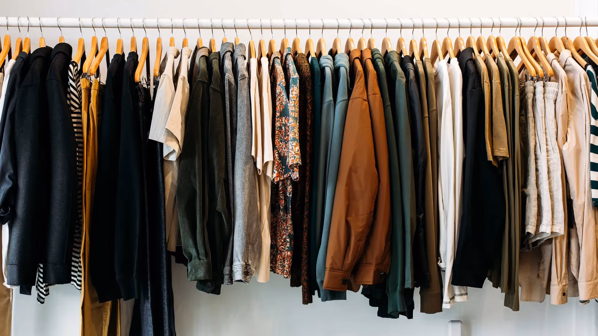 Alt text: A vibrant display of clothing on hangers in a local Hamilton shop, featuring a variety of styles including casual shirts, jackets, and trousers, showcasing Hamilton's best local fashion. Support local businesses and discover unique styles.