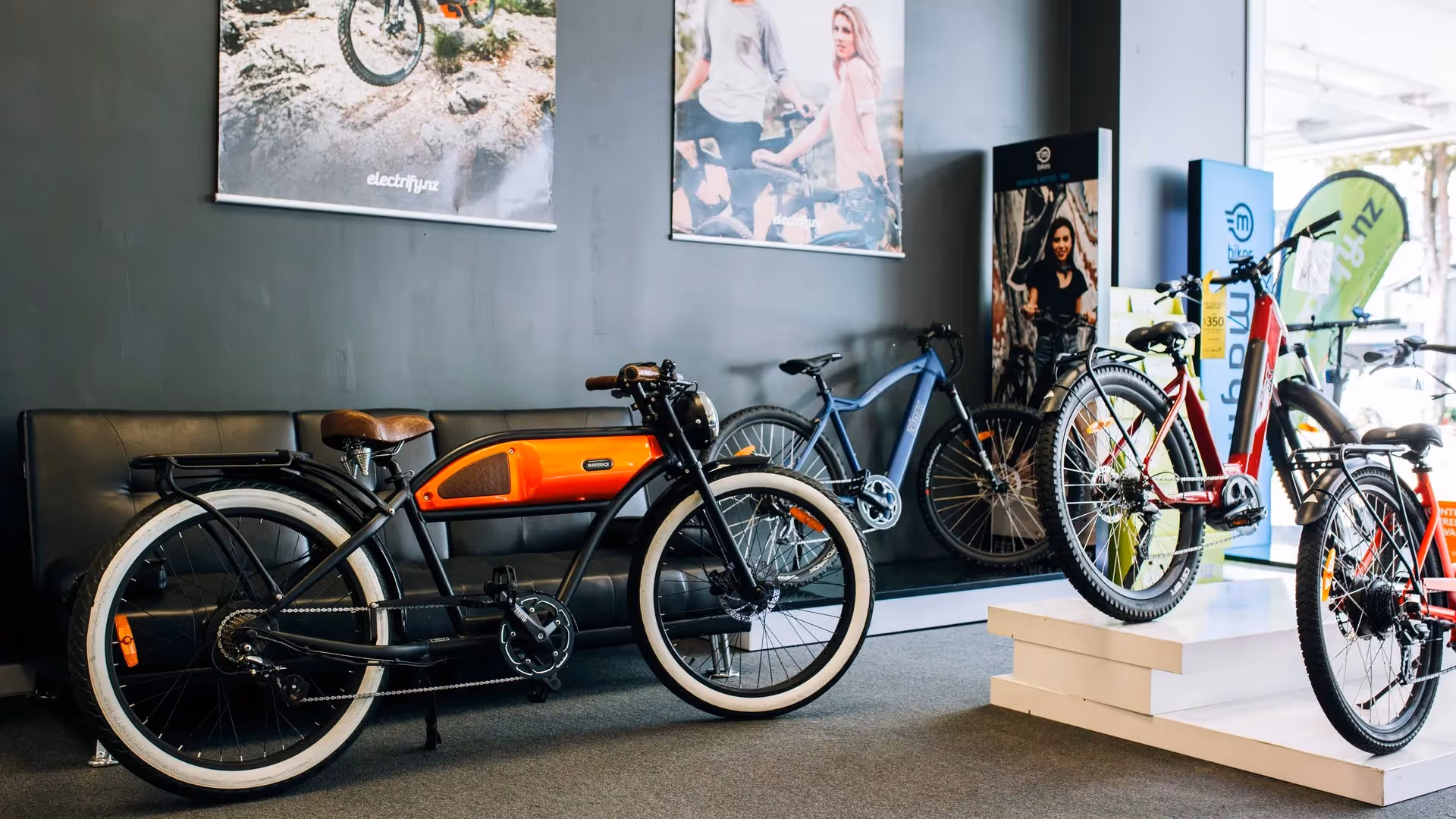 Alt text: Showcasing a modern bike shop in Hamilton, featuring electric bikes in vibrant colours. The display highlights local businesses and promotes community experiences. Great for cycling enthusiasts looking for quality rides.