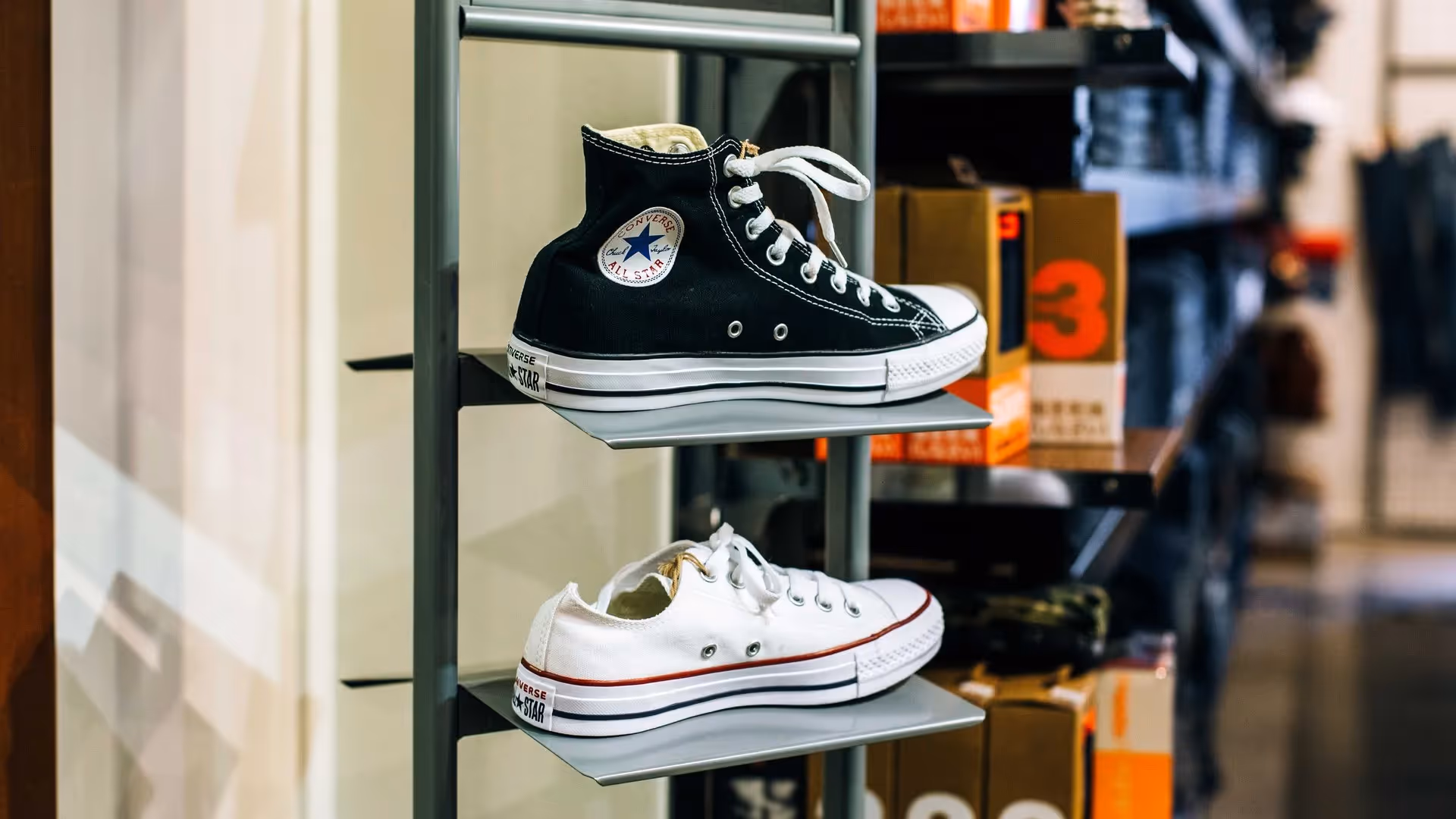 Alt text: "Display of black and white Converse shoes on a rack in a local Hamilton shop, showcasing stylish footwear options and supporting the city's vibrant community and local businesses."