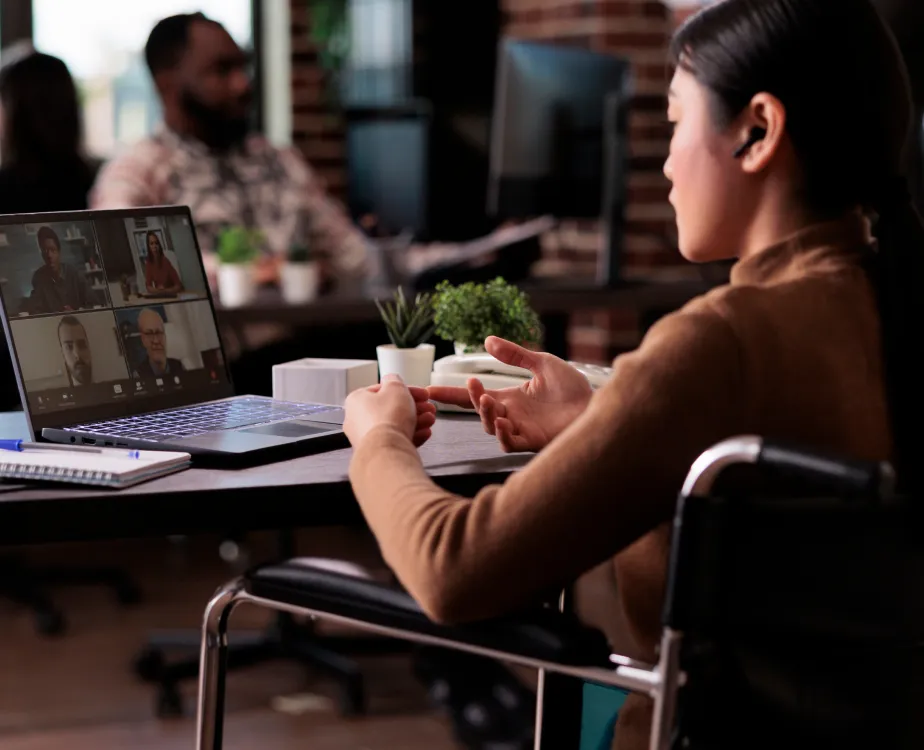 An Asian looking woman using her laptop having a Video Meeting with her Team.