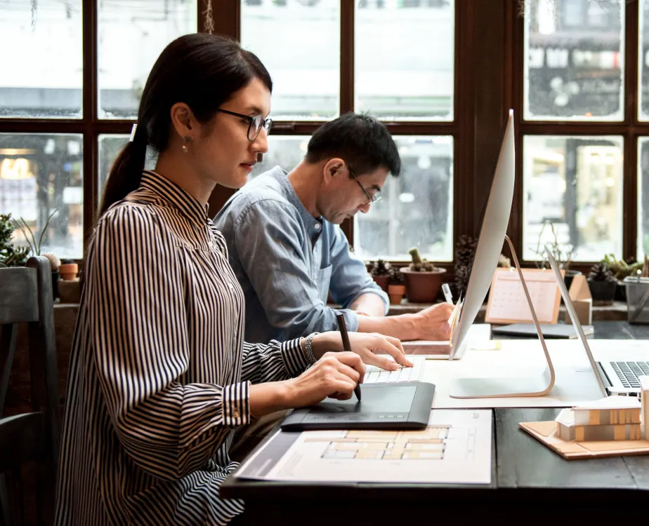 Asian Woman and Man, working in their Desk using Computers and Tablets.