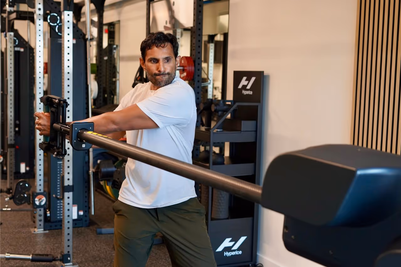 A member in his late thirties pressing a landmine bar during a strength session