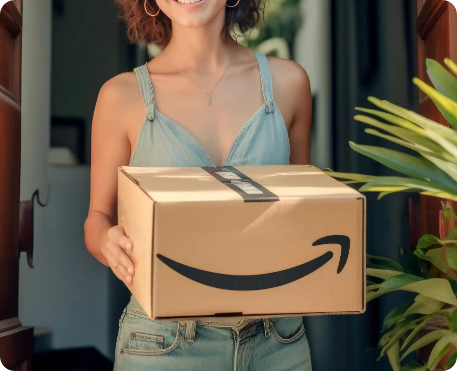 A smiling woman holding a box with Amazon Logo