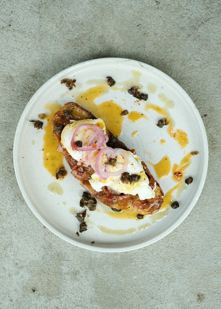 Poached eggs on toast with capers and pickled onion