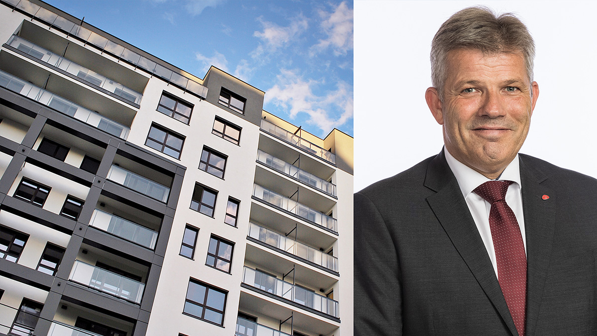 boligblokk med portrett av kommunalminsteren ved siden av