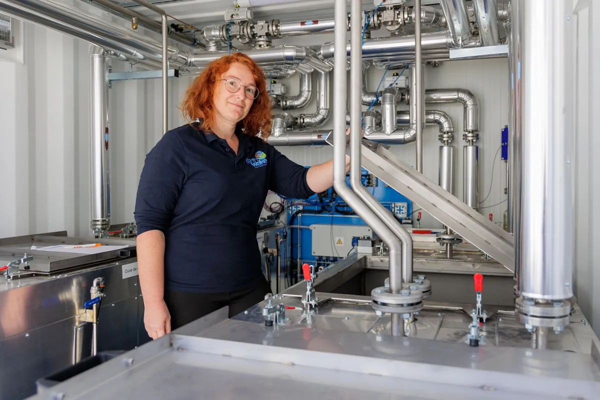 Technicienne inspectant système tuyauterie industrielle unité Chrysalis traitement plastique