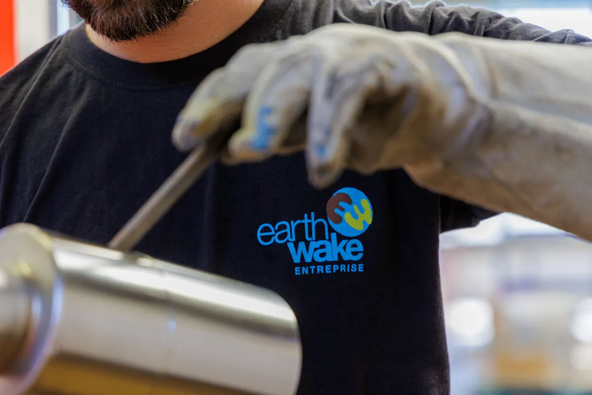Technicien portant tee-shirt Earthwake manipule équipement pyrolyse avec gants protection