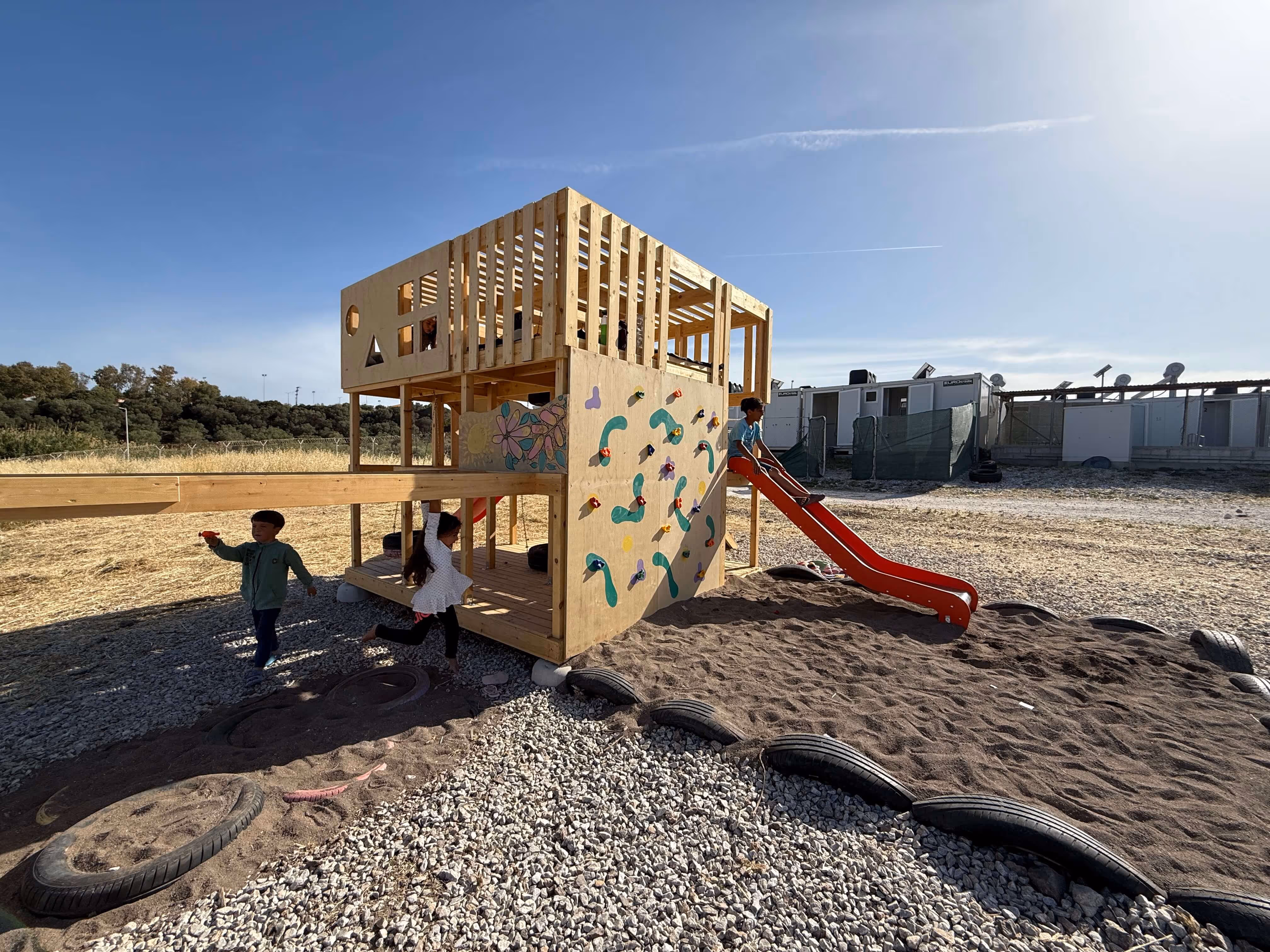 Relief Crew Volunteers offering hands on support to residents of a refugee camp, working alongside people who have been forced to flee their homes to build a safe, creative space for kids to play.