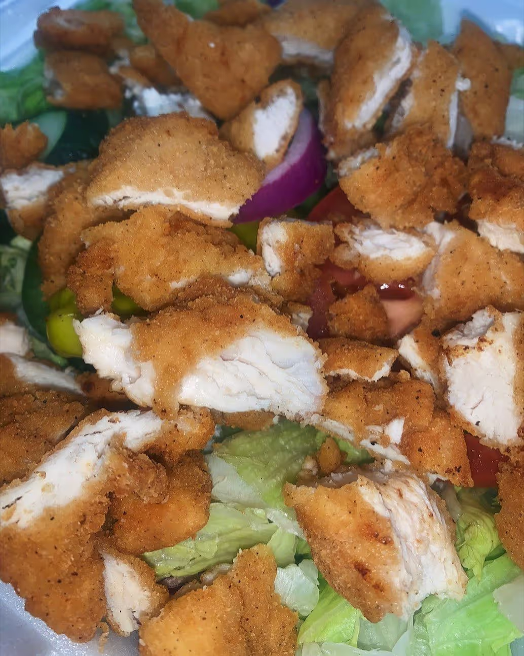close up of sliced fried chicken with lettuce
