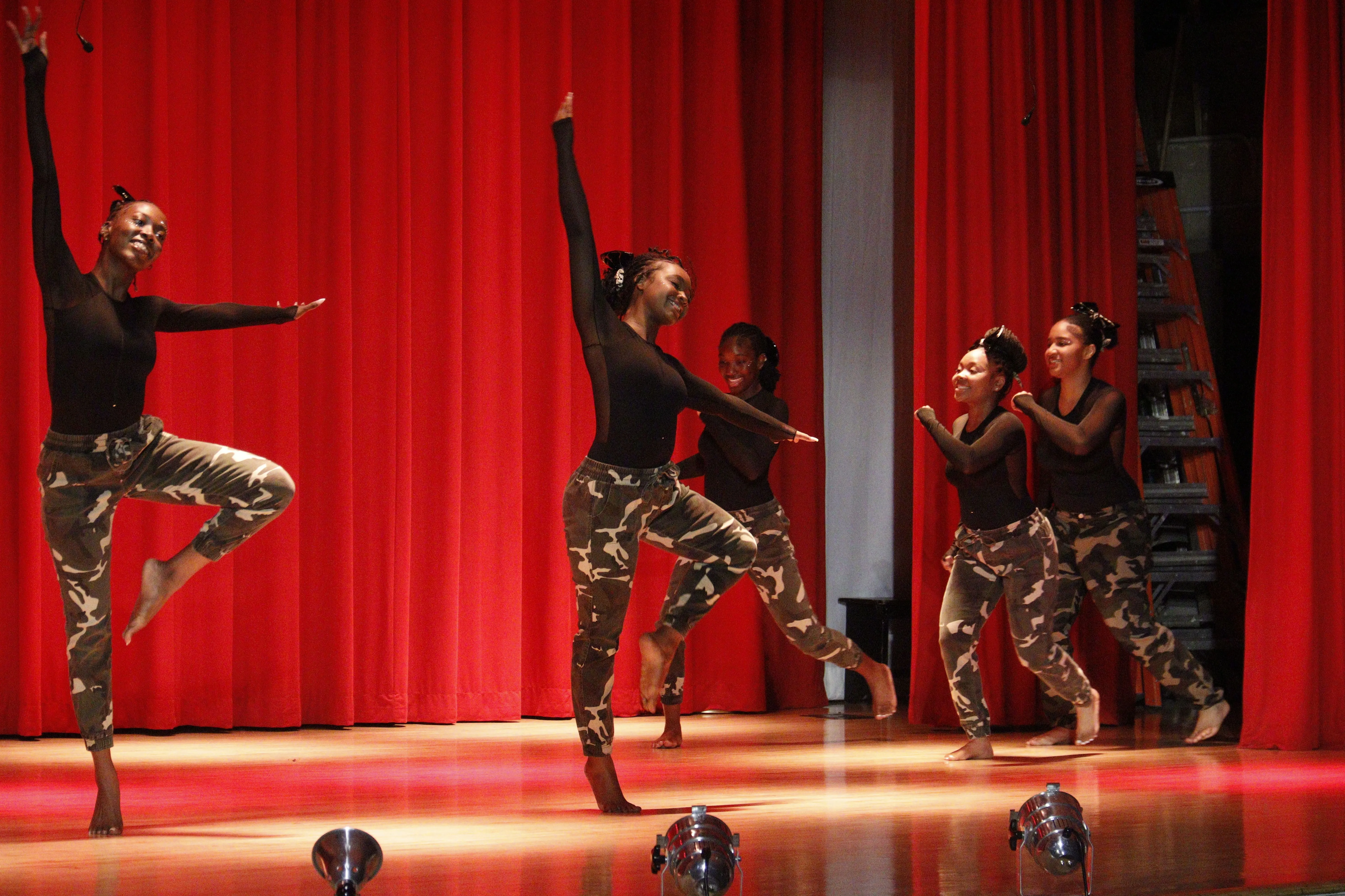 Three dancers performing energetic routine
