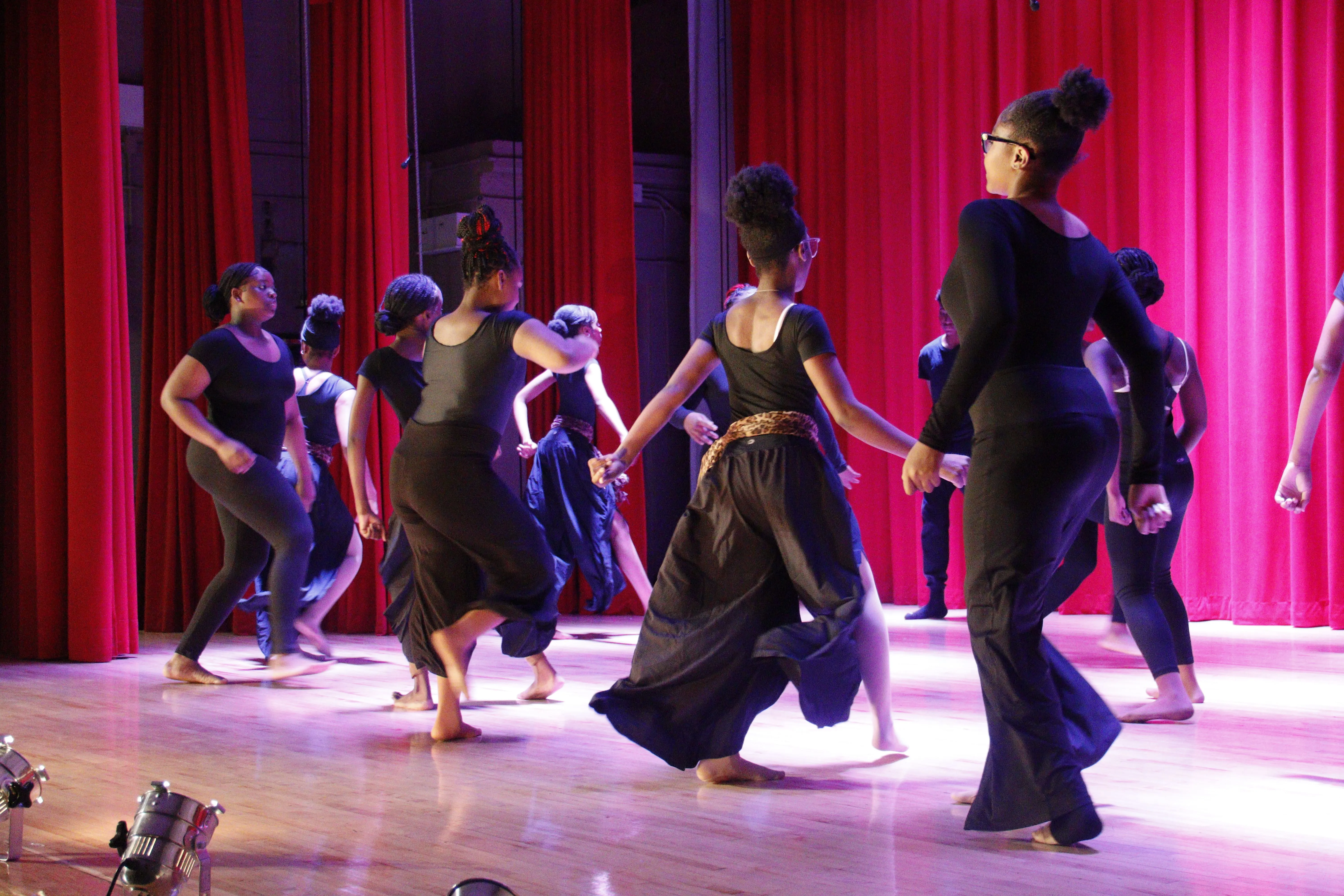 Dancers in flowing black dresses