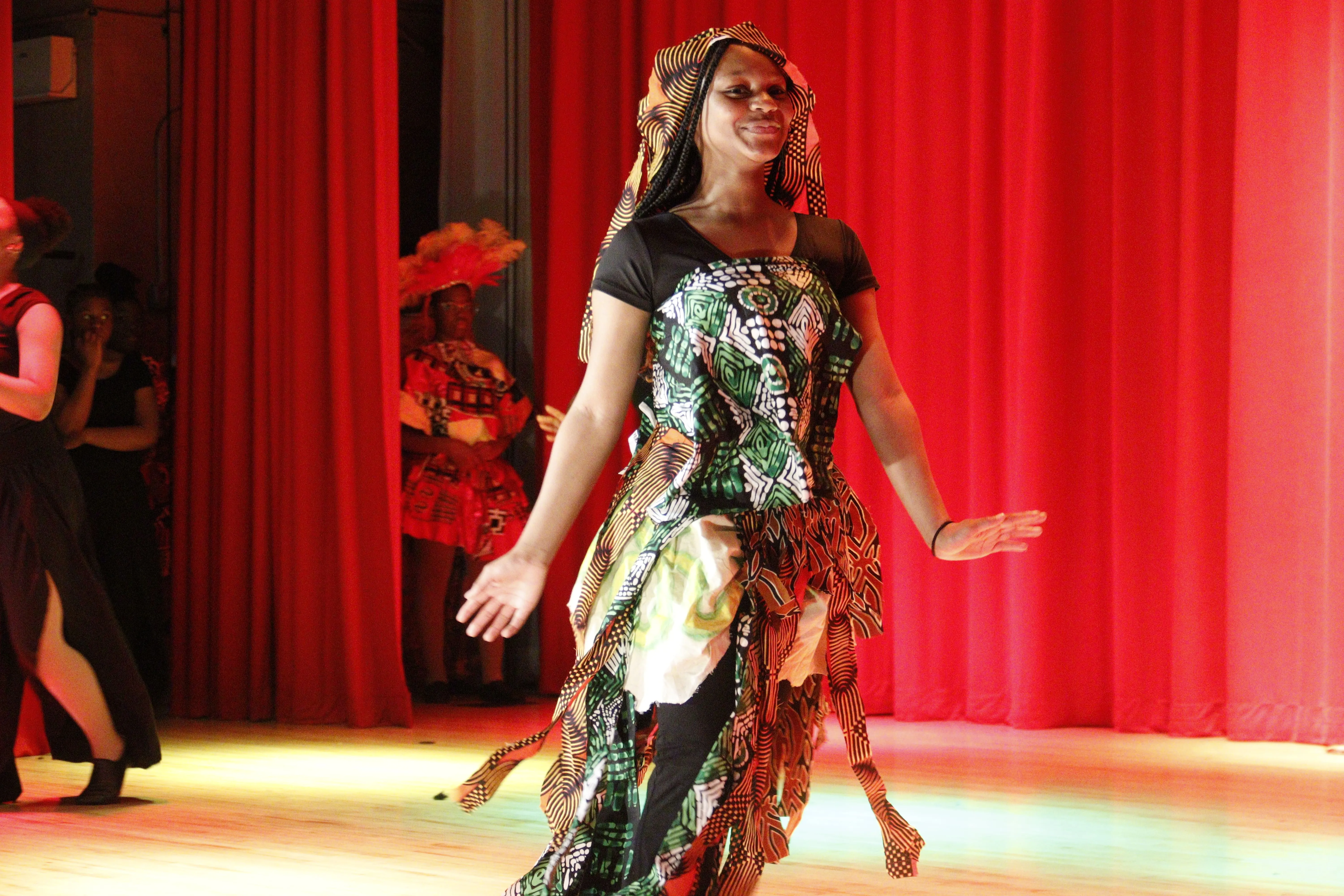 Student dancing in colorful costume on stage