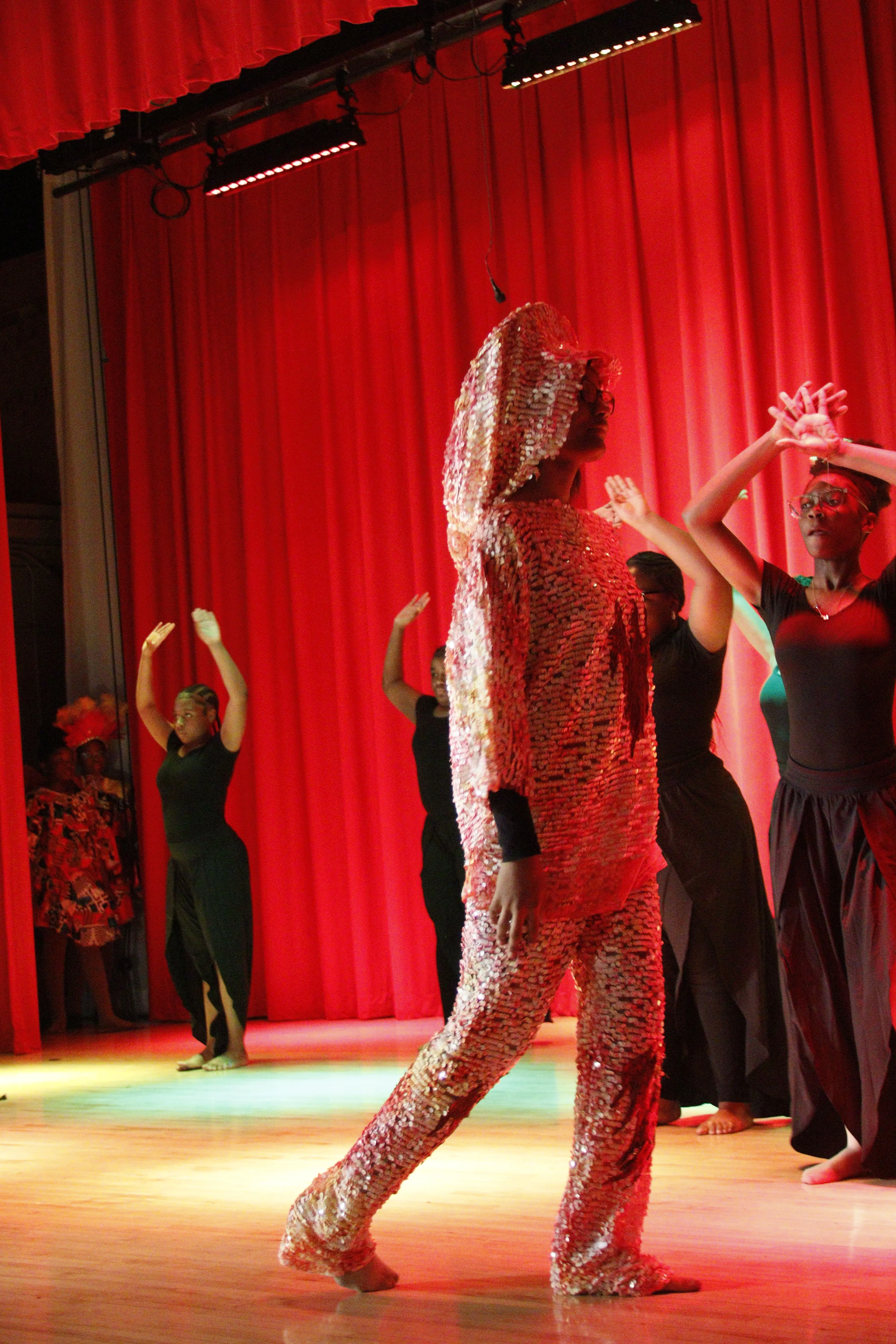 Student dancing on stage with others behind